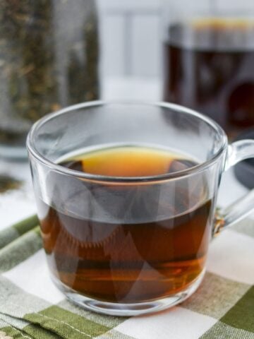 A glass mug full of herbal tea.