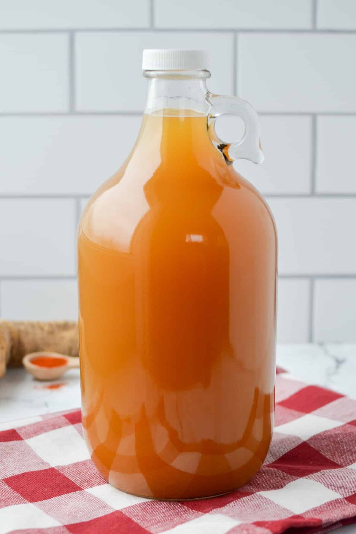 A large jug of fire cider resting on a check napkin.