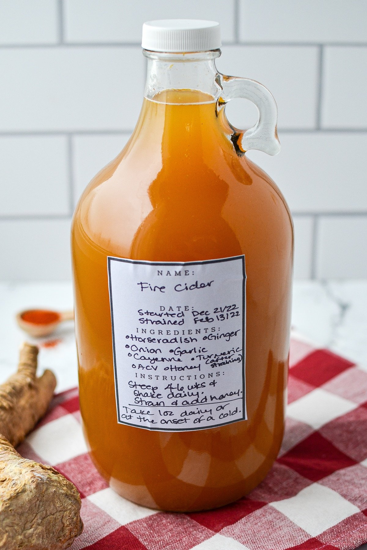 A large jug containing fire cider, and a sticker label fixed on the front.