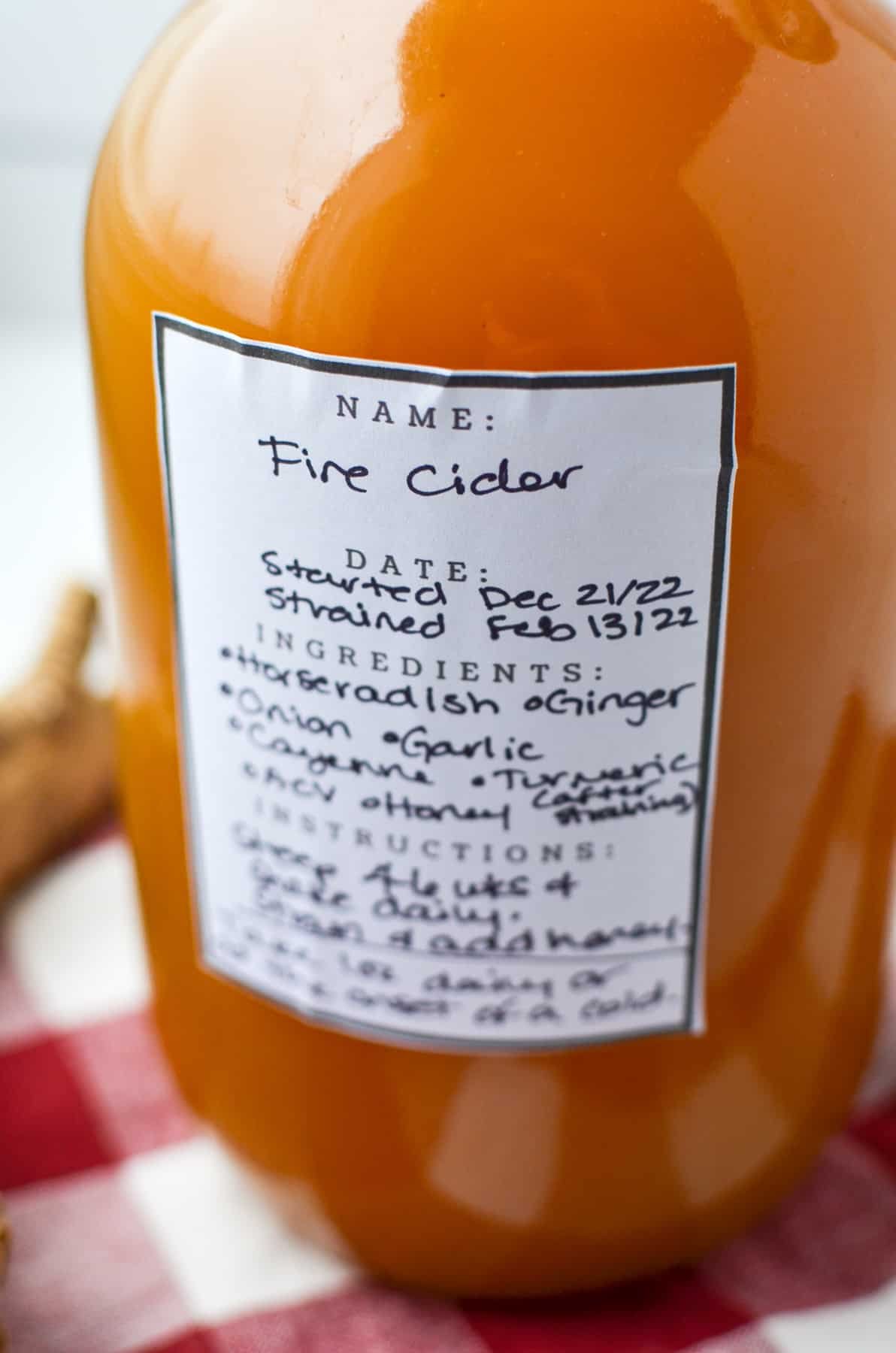 A close up of a label on a jar describing the contents as fire cider.