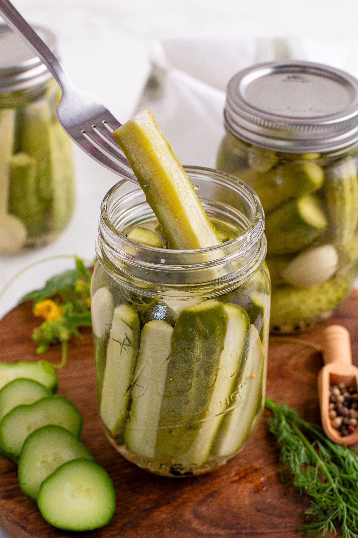 Using a fork to retrieve a pickle spear from a canning jar.