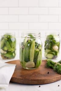 3 jars of prepared cucumbers ready to be made into pickles.