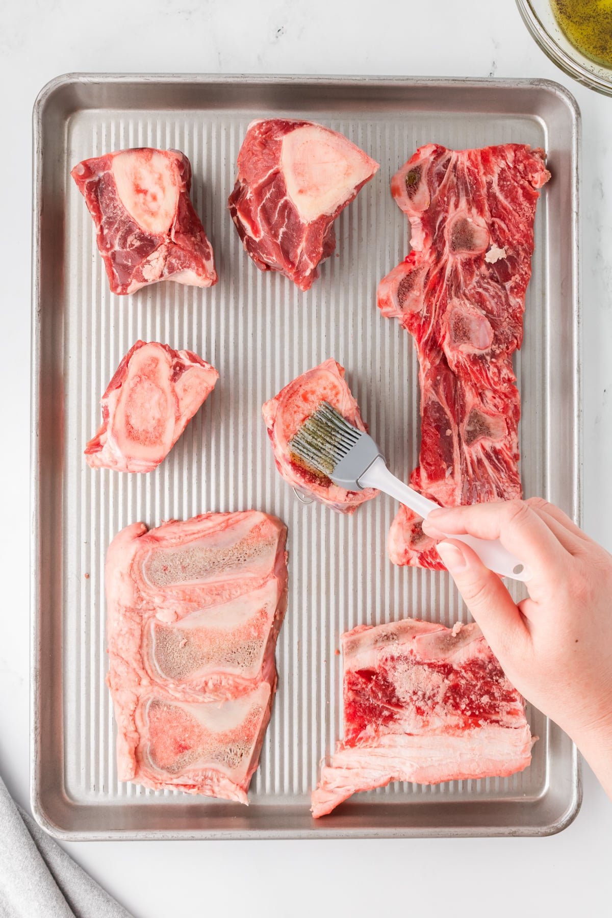 Brushing beef bones with seasoned oil.