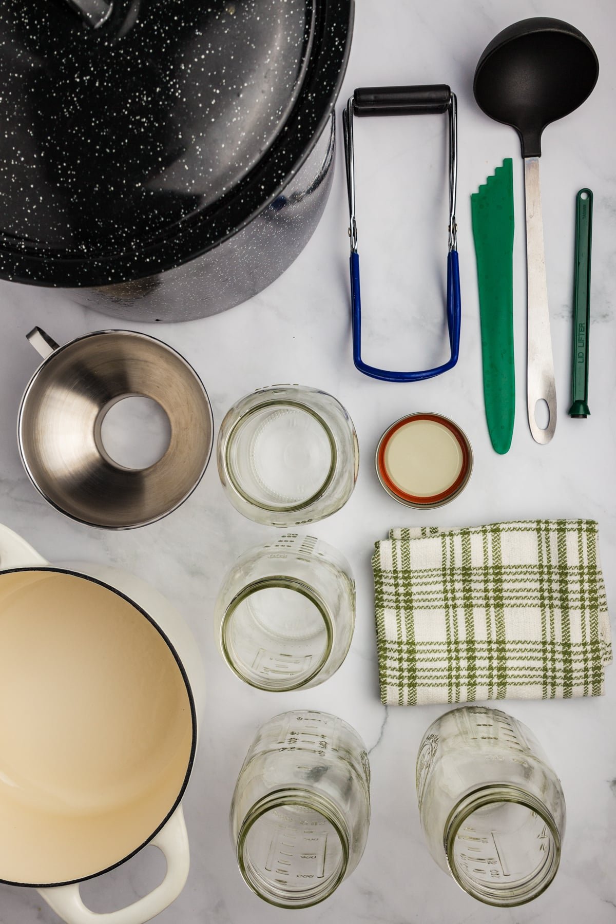 The equipment needed to water bath can: canner, funnel, lid lifter, jar lifter, canning jars, etc.