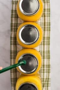 Adding lids to canning jars using a magnetic lid lifter.