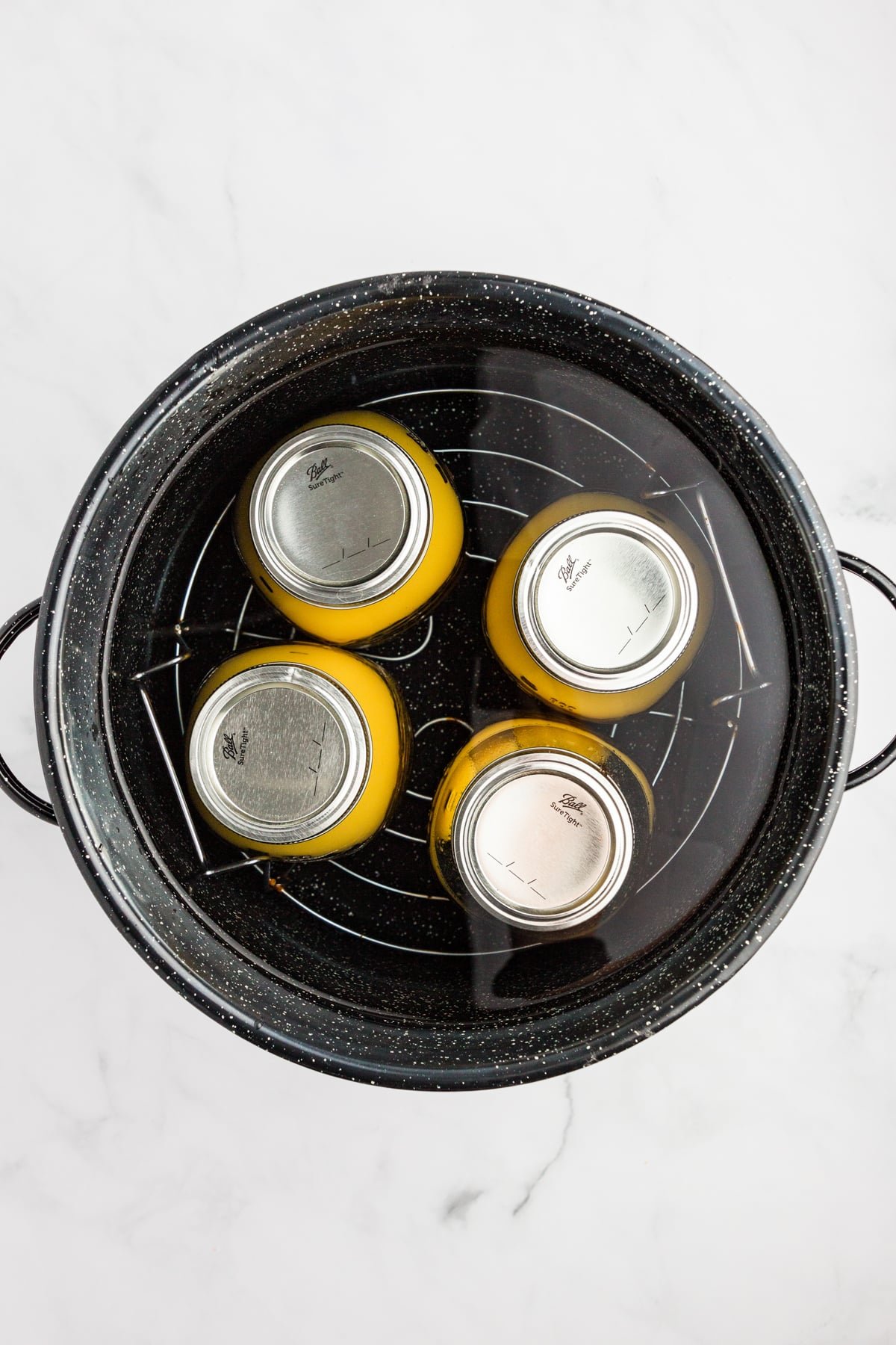 A water bath canned with 4 quarts submerged under the water.