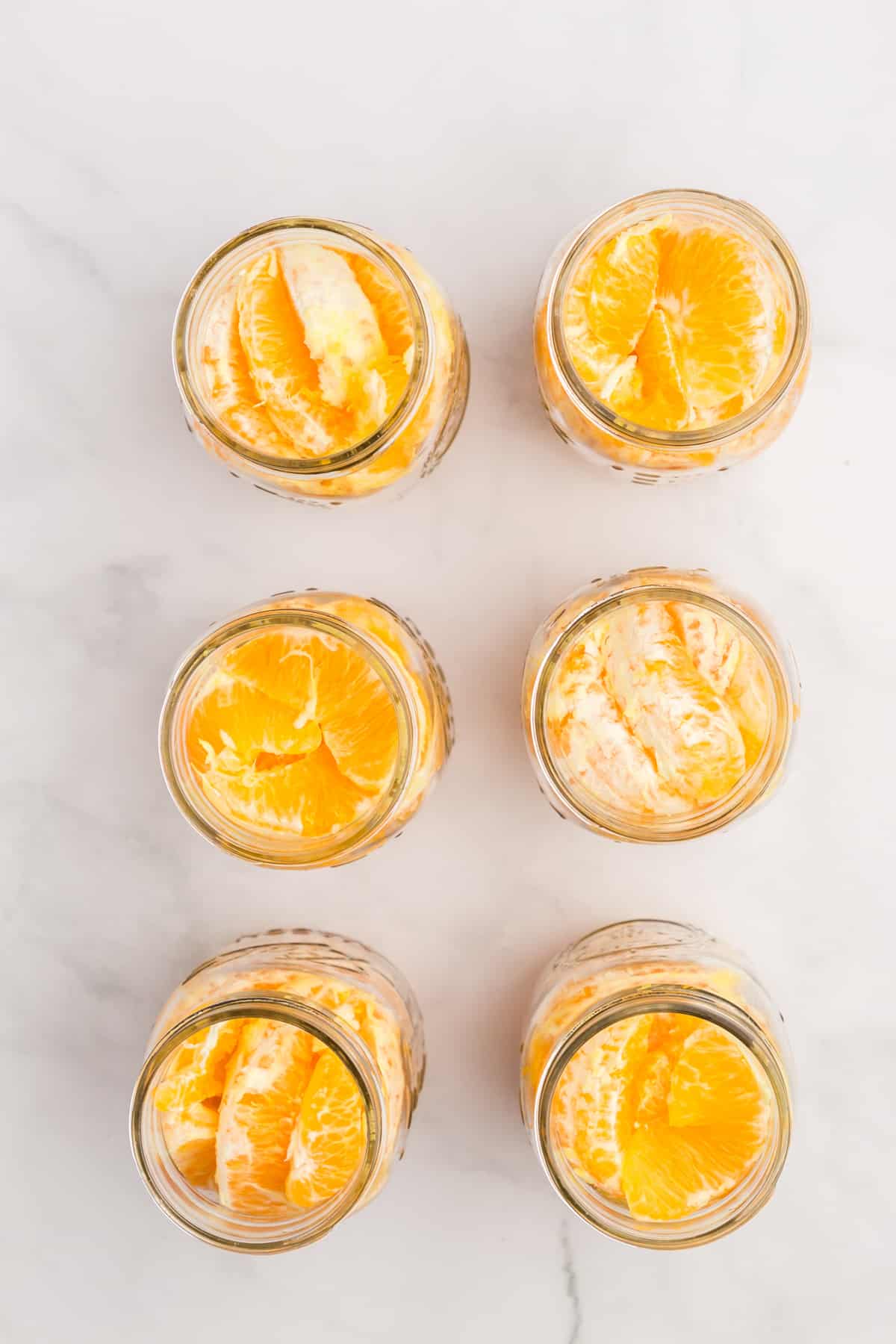6 pint jars filled with orange segments.