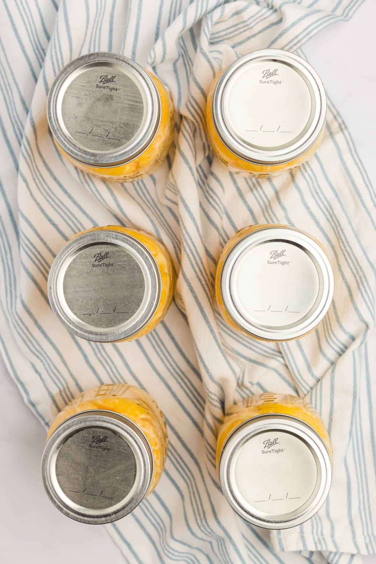 An overhead image of 6 pint jars on a kitchen towel.