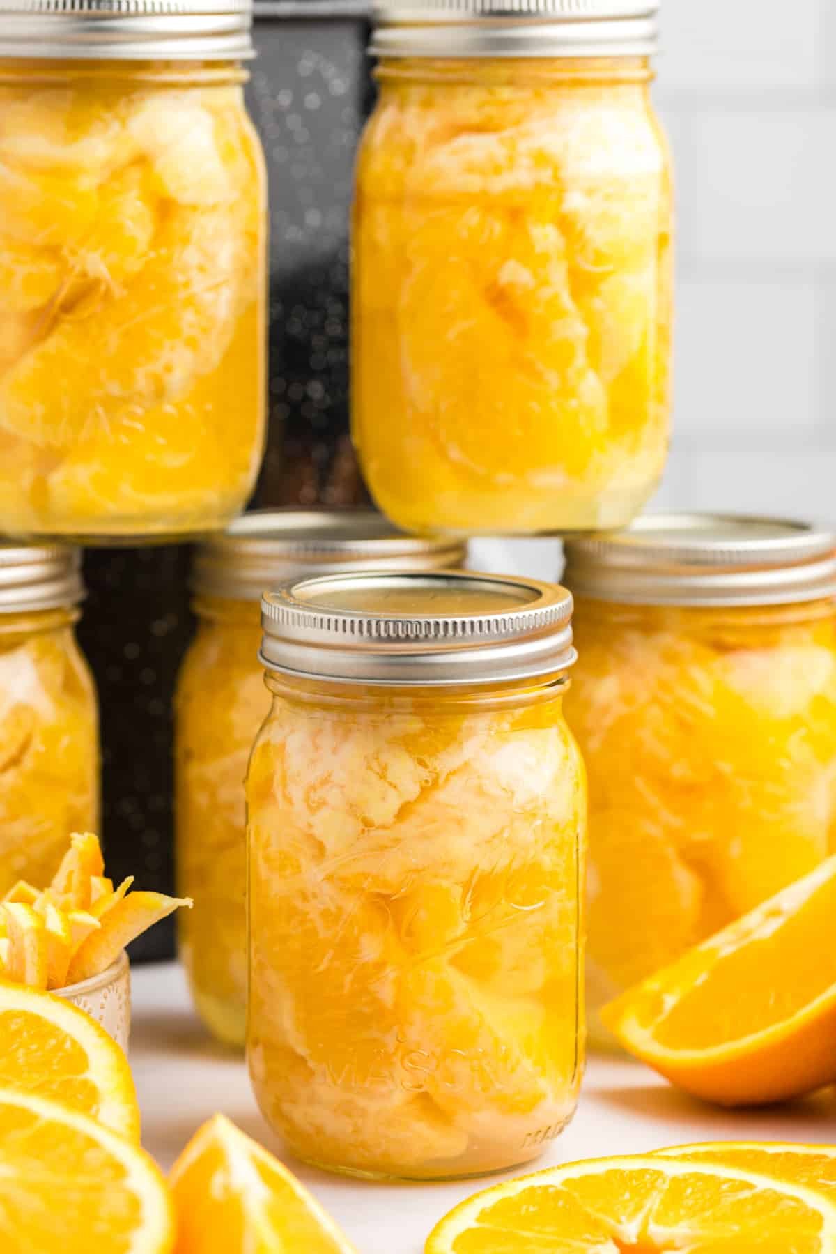 A stack of canning jars filled with orange segments.