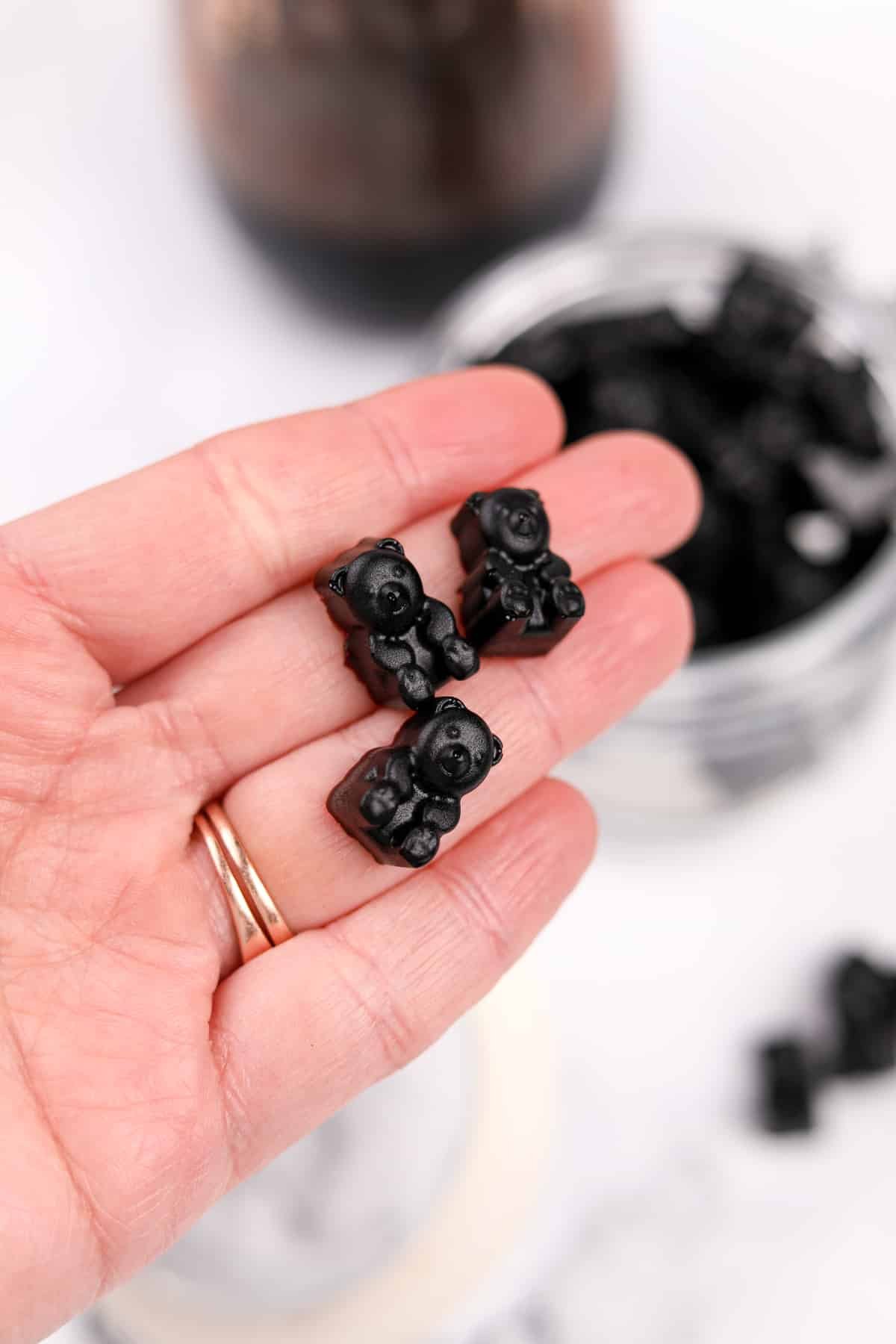 A hand holding gummy bears that have been made with elderberry syrup.