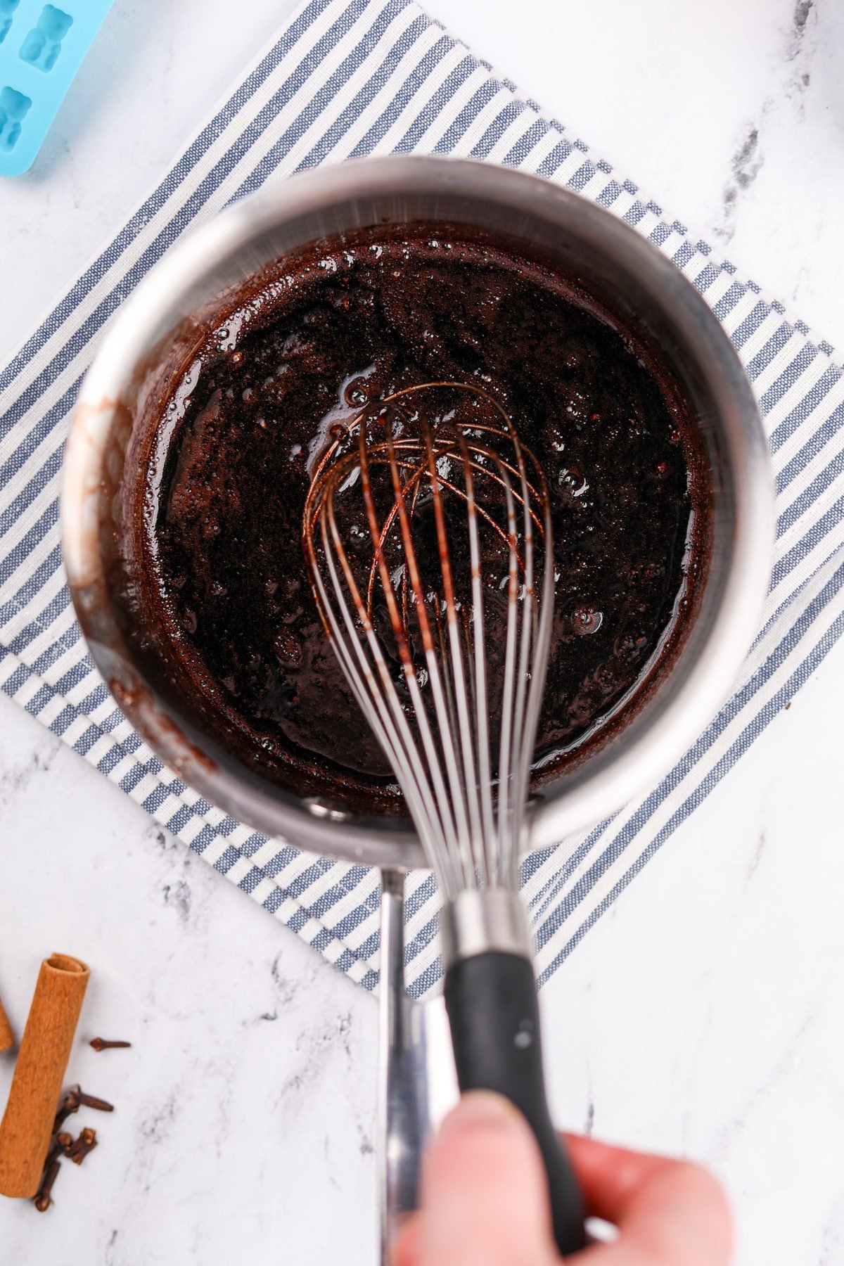 Whisking elderberry syrup with gelatin powder.