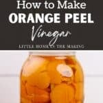 Orange peels in a large glass jar with vinegar poured in.