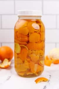 A jar of oranges covered in vinegar.