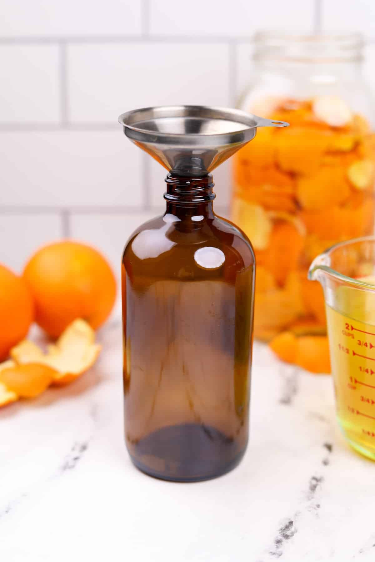 An amber glass bottle with a funnel fitted on the top.