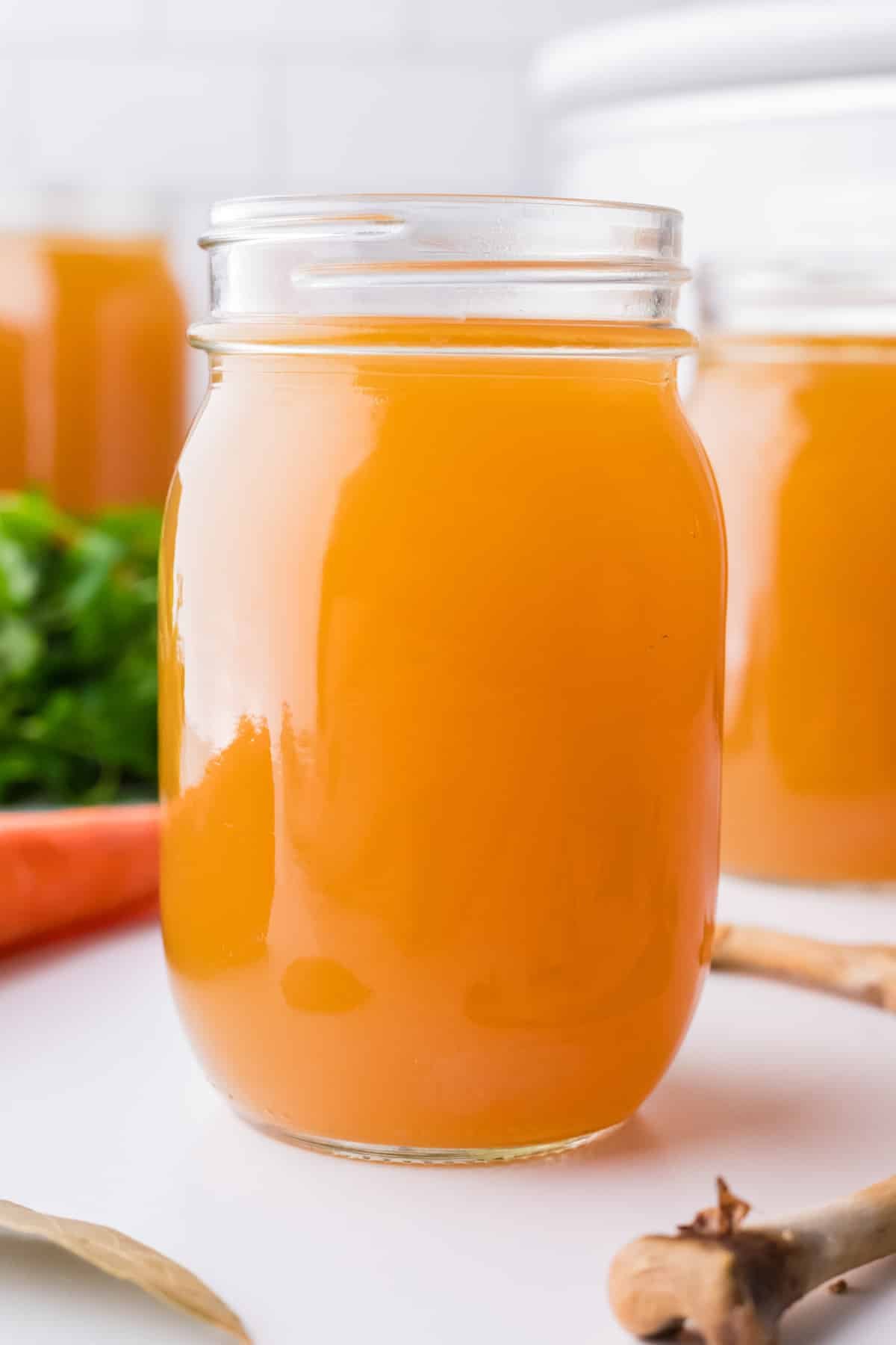 A glass canning jar filled with chicken broth.