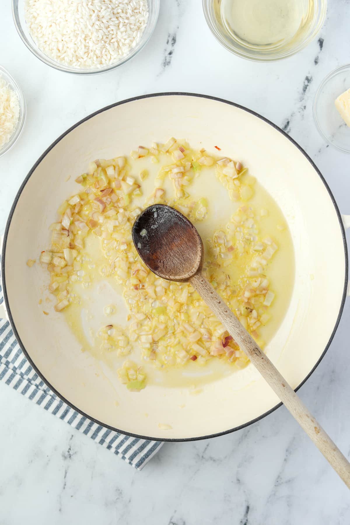 Shallots cooking in oil and butter in an enameled skillet.