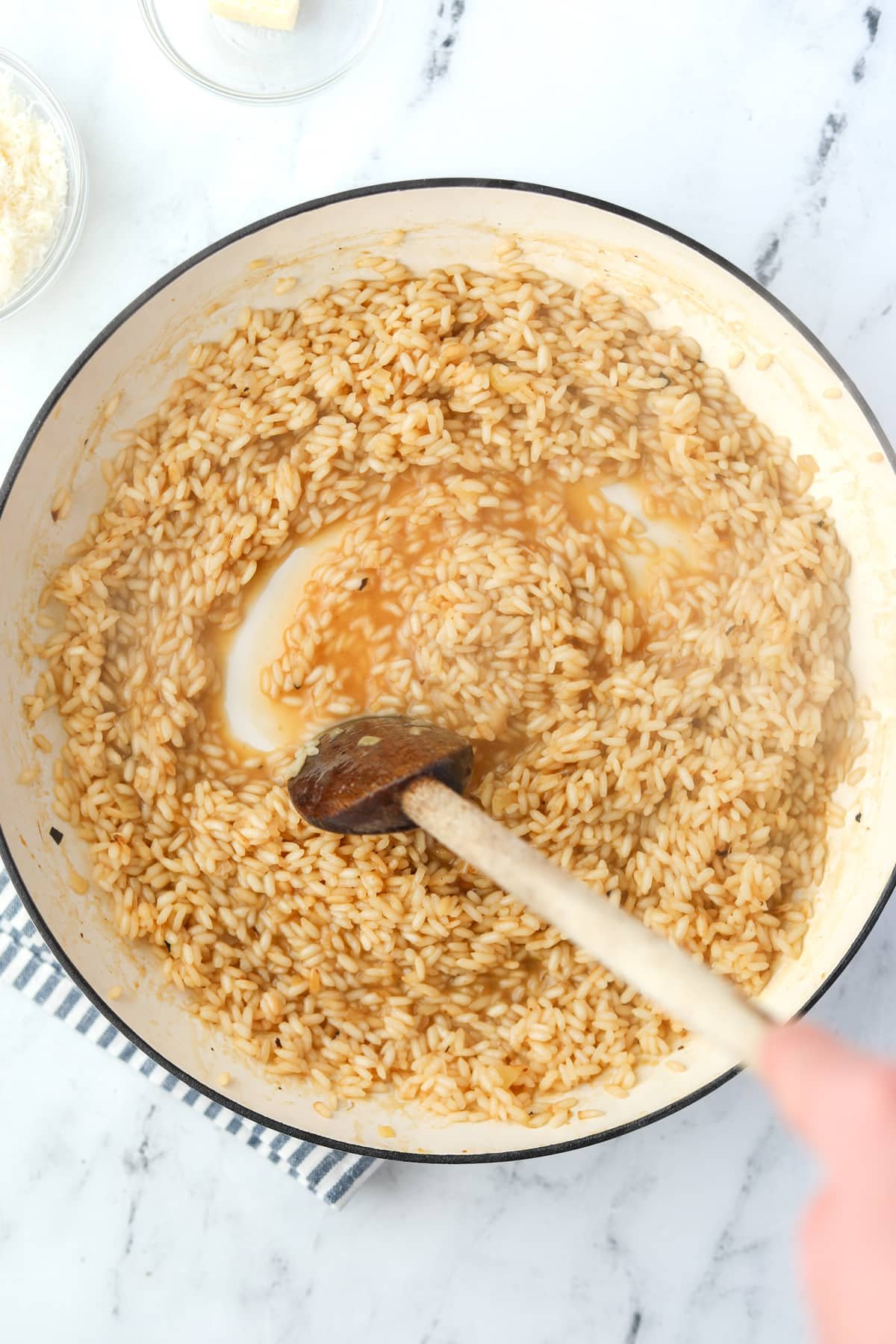 Stirring rice with a wooden spoon.