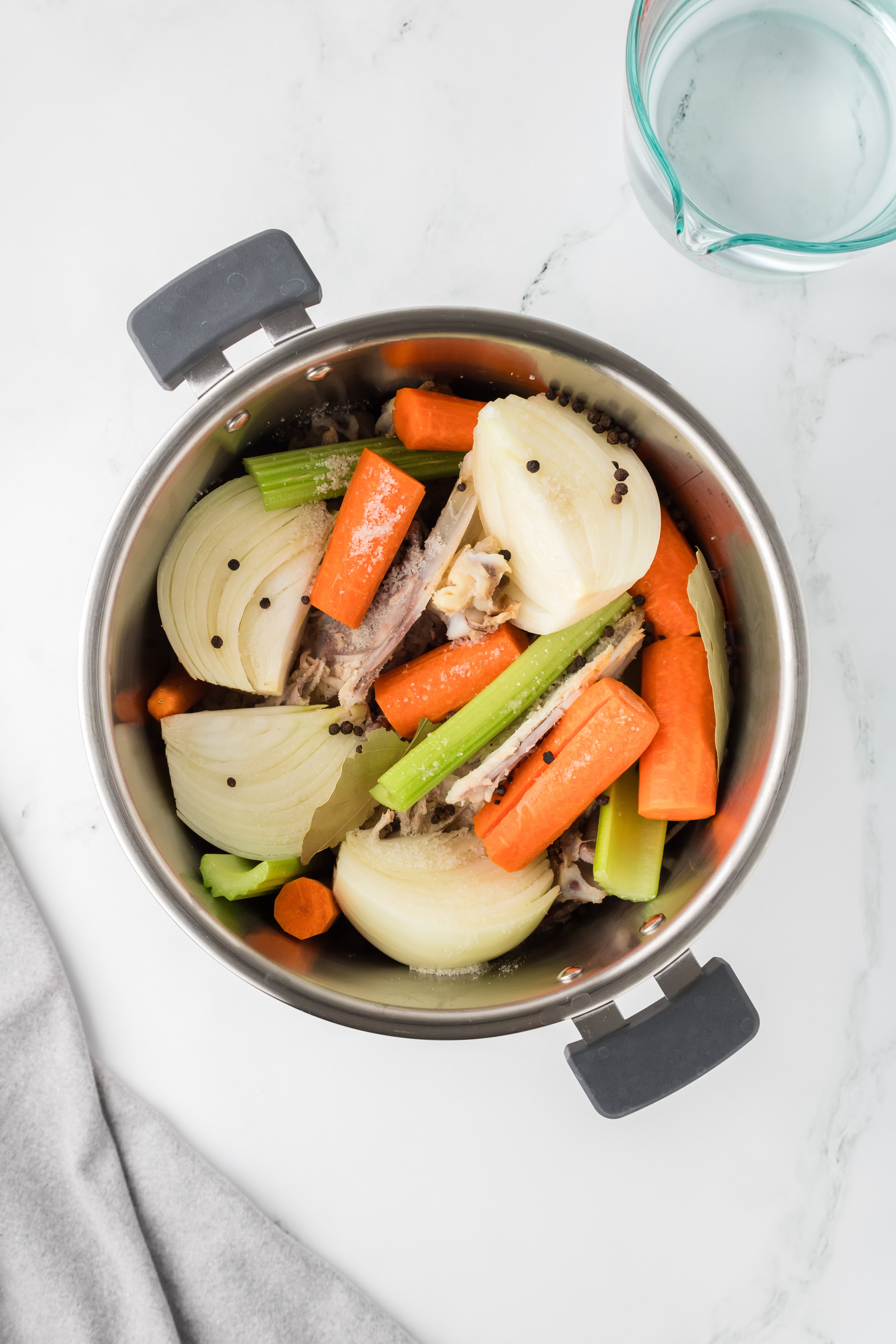 An Instant Pot filled with bones, onions, celery, and carrots.
