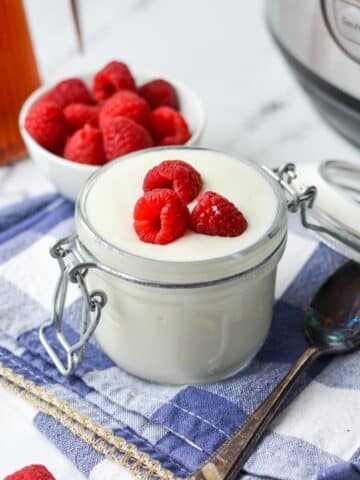 Yogurt topped with fresh raspberries.