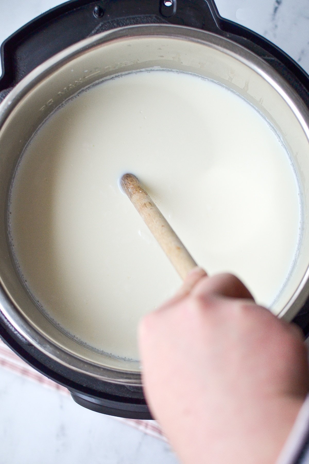 Stirring a large Instant Pot full of milk.