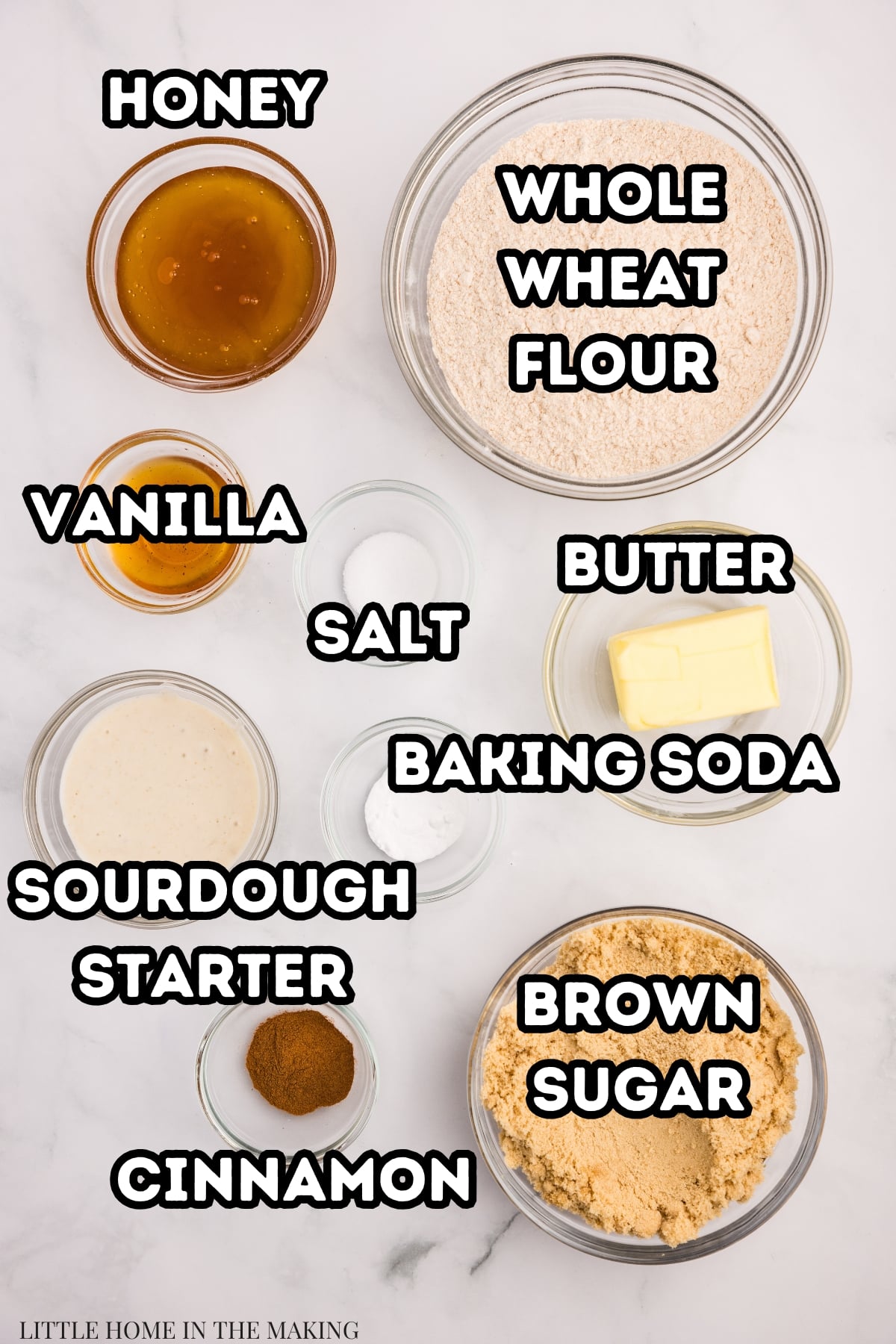 The ingredients needed to make homemade graham crackers including sourdough discard, whole wheat flour, honey, butter, and others.
