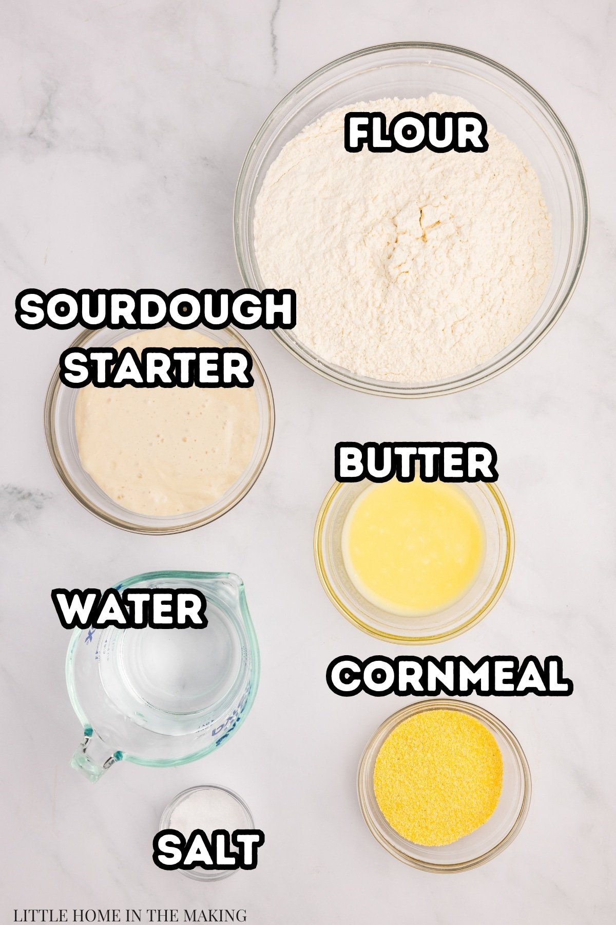 The ingredients needed to make sourdough english muffins: starter, flour, water, butter, cornmeal, and salt.
