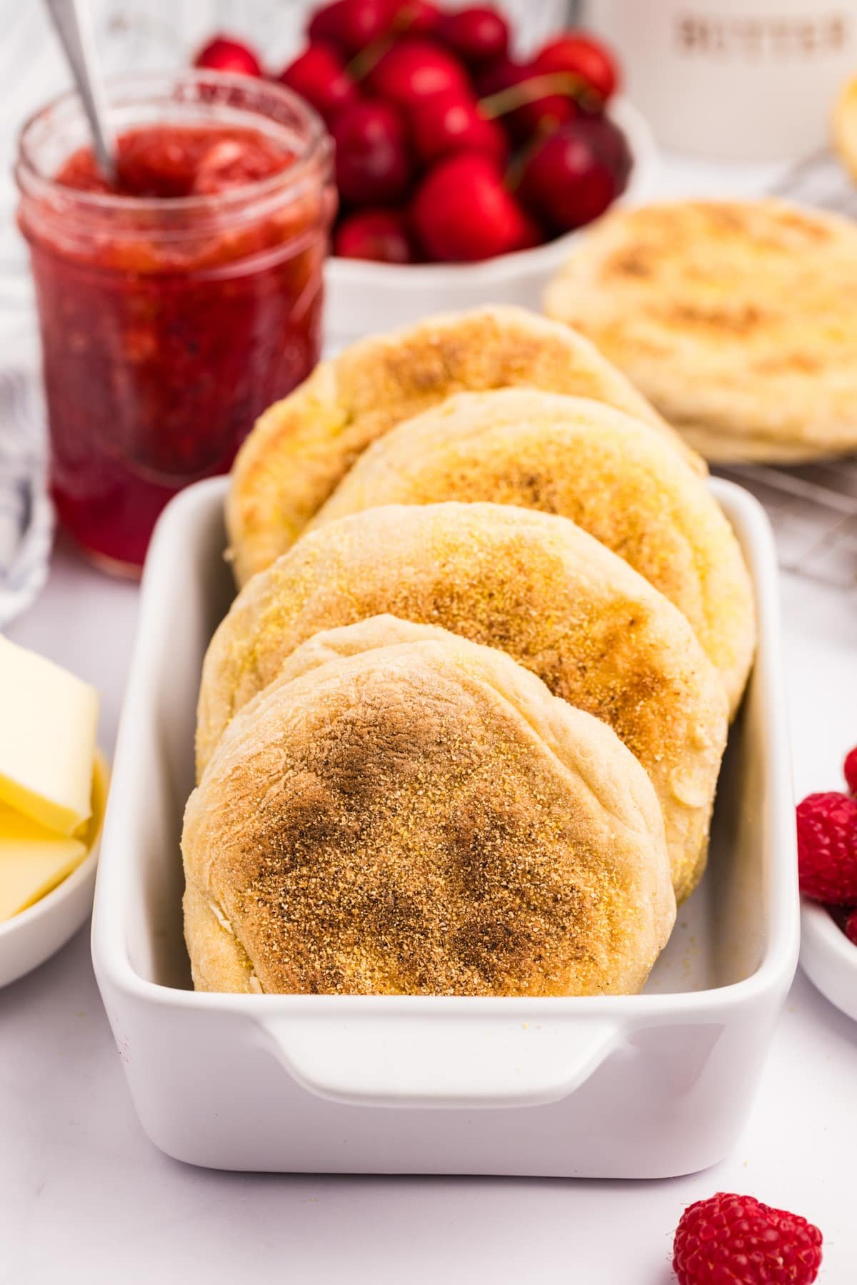 A small baking dish filled with several homemade english muffins.