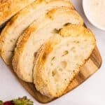 Slices of sourdough bread on a wooden cutting board.