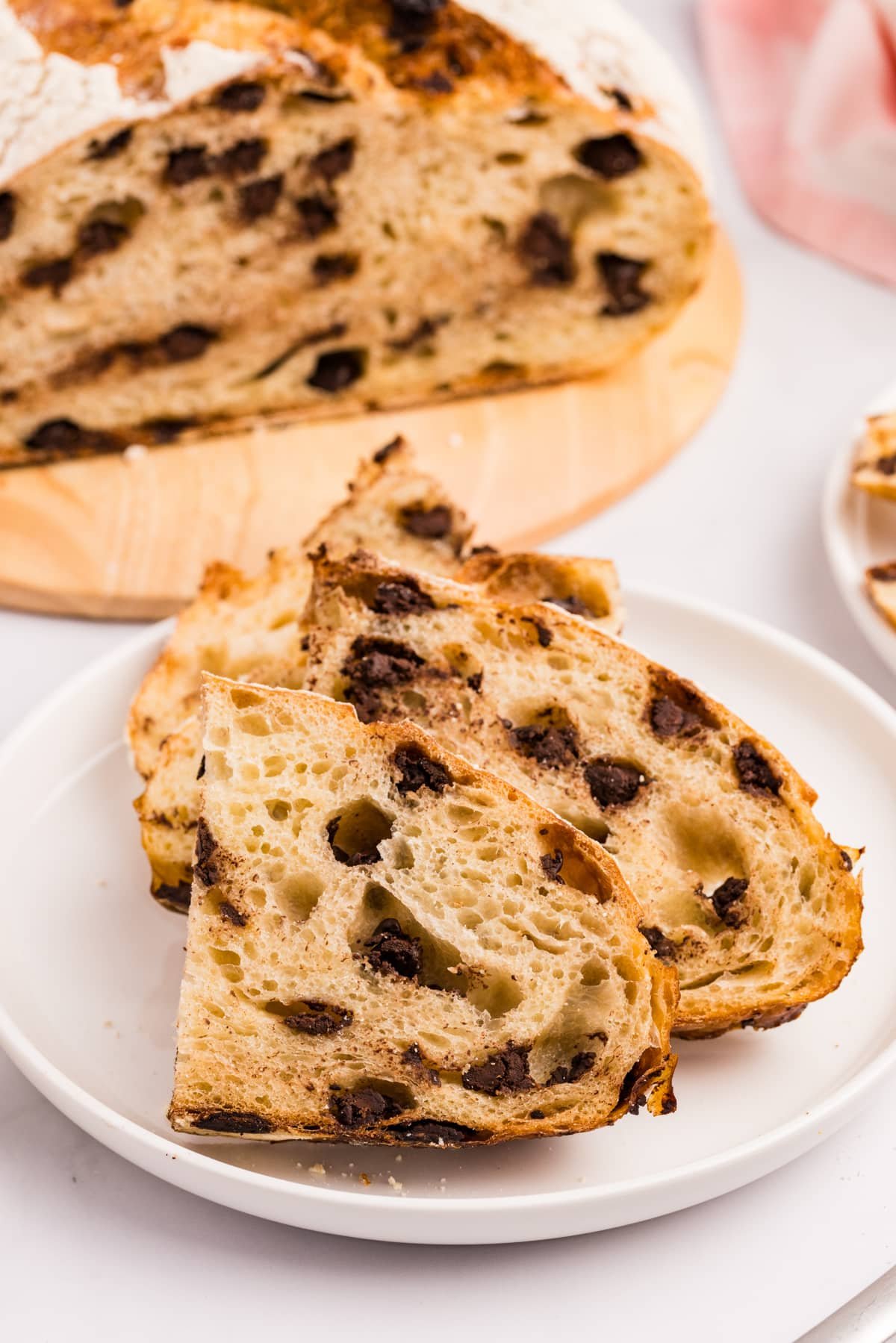Half slices of sourdough chocolate chip bread on a white plate.