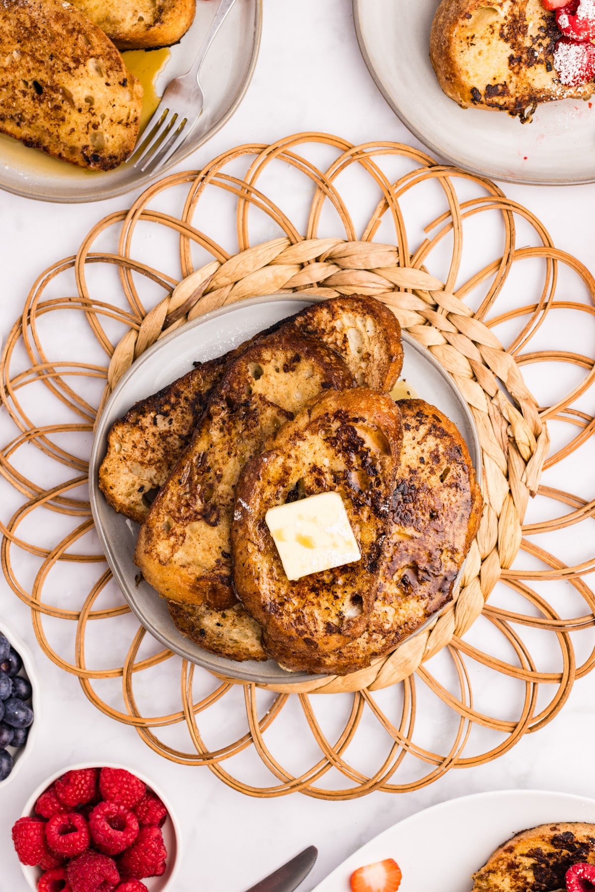 Several slices of french toast with a pat of butter on top.