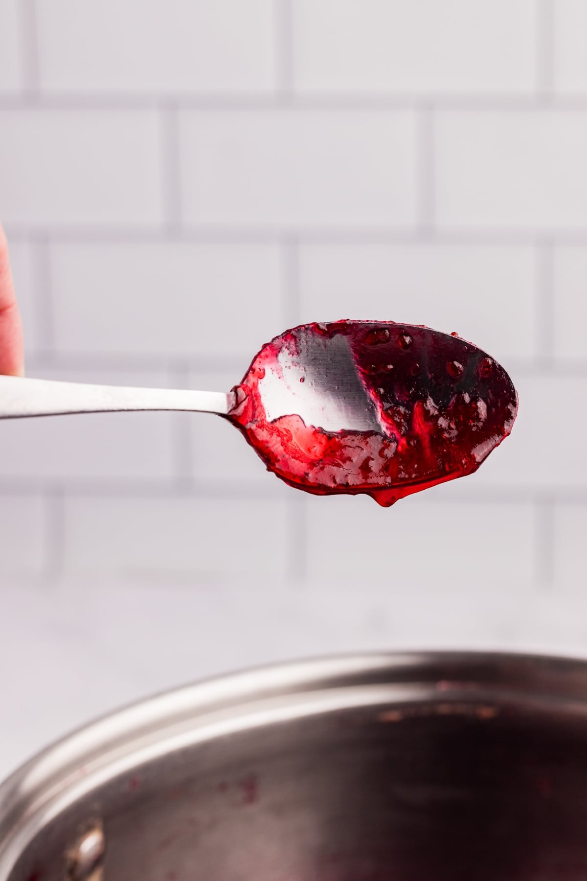 A spoon with cranberry "sheeting" off of the spoon, indicating its done.