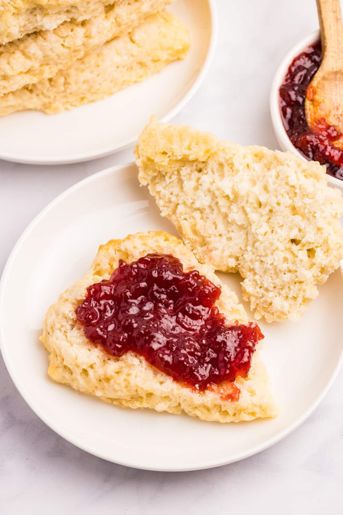 A scone with jam spread on one half.
