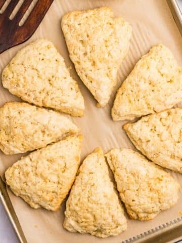 Sourdough scones shaped as wedges on a baking sheet.