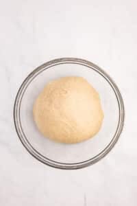 A small ball of bread dough in a bowl, ready to rise.
