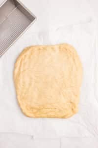Dough flattened into a rectangle on a counter.