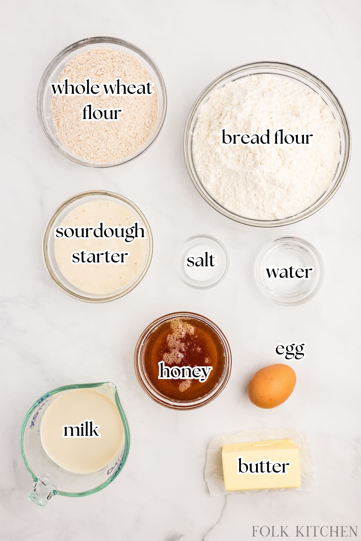 The ingredients needed to make sourdough whole wheat sandwich bread, including flour, milk, butter, and honey.