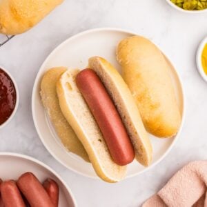 A homemade sourdough hot dog bun with a cooked hot dog in the center.