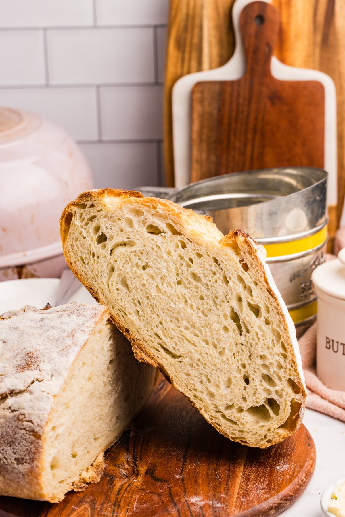 A loaf of sourdough bread sliced in half and resting on the other half.