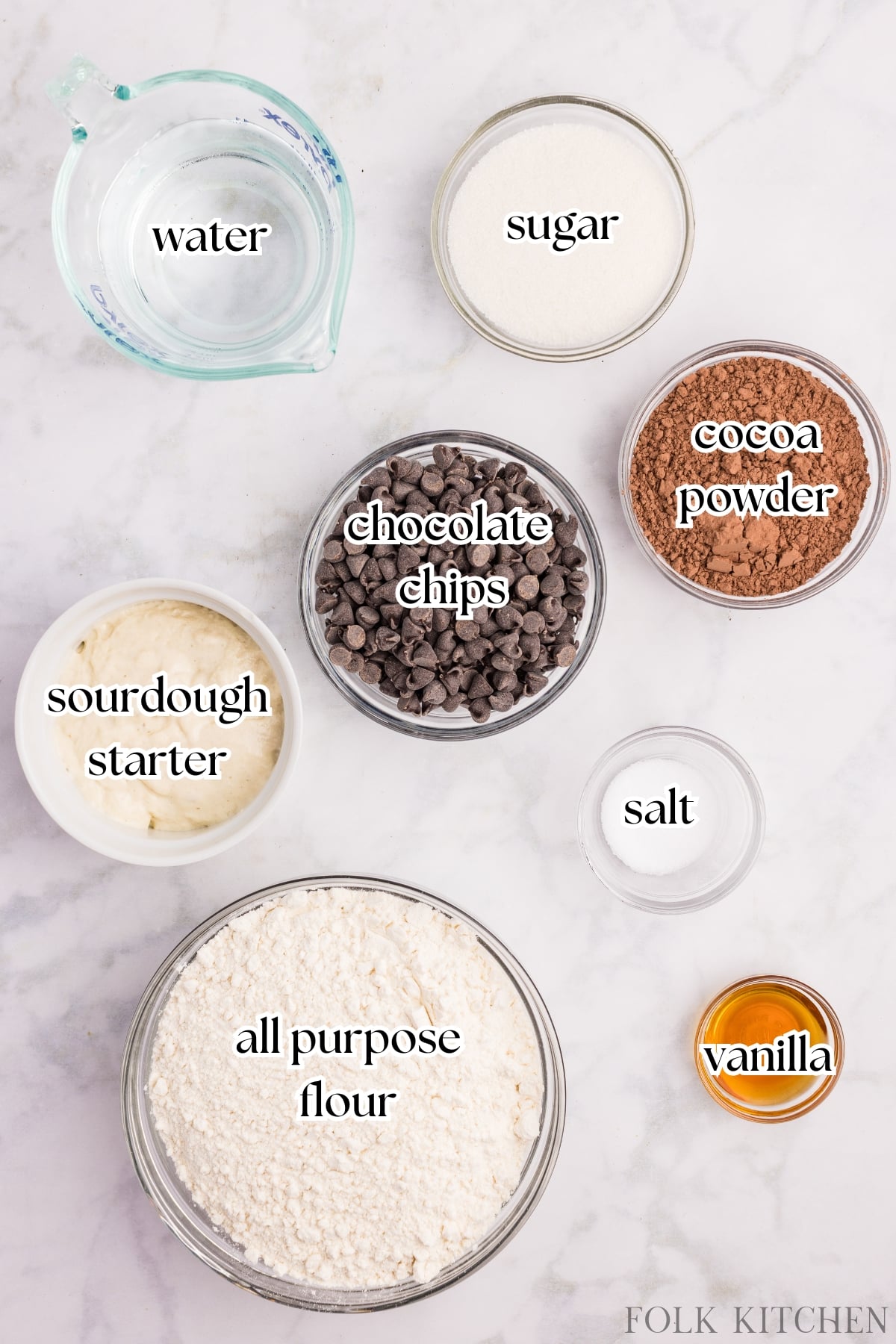 Various bowls containing various ingredients, including flour, chocolate chips, cocoa powder, and sourdough starter.