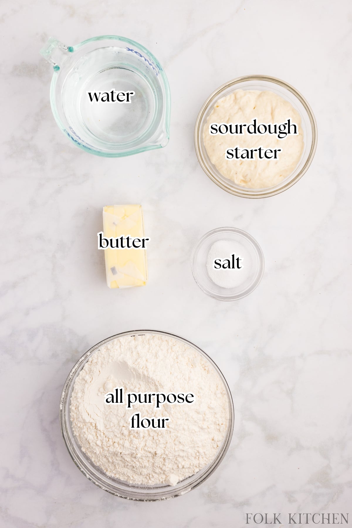 The ingredients needed to make sourdough croissant bread, including butter, flour, water, starter, and salt.