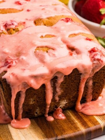 A loaf of sourdough bread with strawberry glaze dripping down the sides.